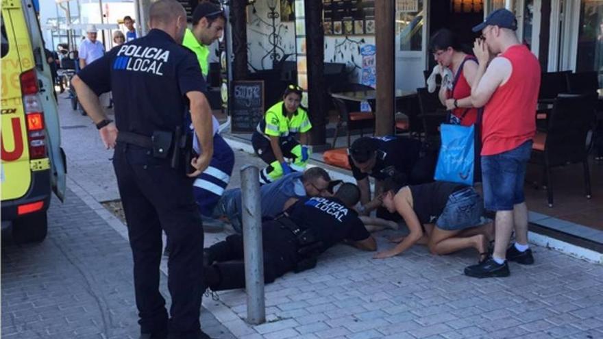 Agentes de la Policía Local, junto con las asistencias sanitarias, atienden al menor en Cala Bona.