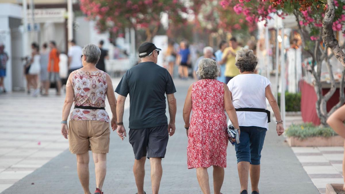 Pensionistas, por el paseo de la playa de Canet.