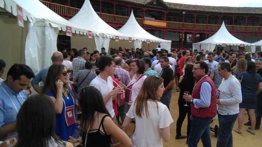 Aficionados degustan en la plaza de toros los vinos de las bodegas participantes en la Feria .