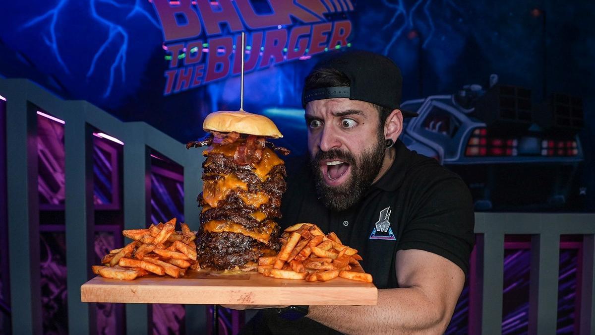 El 'youtuber' Esttik posa con el reto de su hamburguesería, Smash Hiro: una burger de 15 carnes con patatas. Hay que pasarla con un batido de galletas.