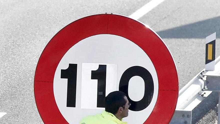 Un operari col·loca un adhesiu en un senyal a Pamplona.