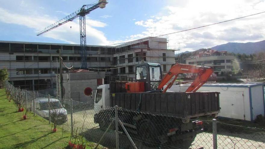 El camión y la pala utilizados ayer para las tareas iniciales de derribo de la ampliación del Kaype, con el edificio de nueva planta detrás.