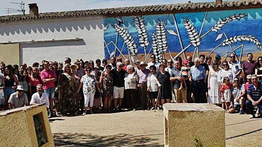 Los participantes en el acto posan ante el mural que representa a los represaliados en Torres del Carrizal.