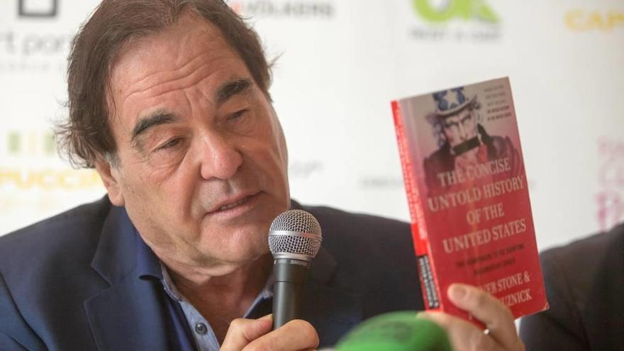 Oliver Stone, con un ejemplar de su libro ´La historia silenciada de Estados Unidos´.