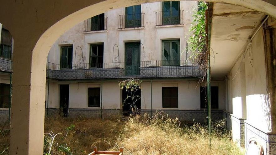 El patio interior del Parador Molina de los Baños de Mula está lleno de maleza y suciedad.