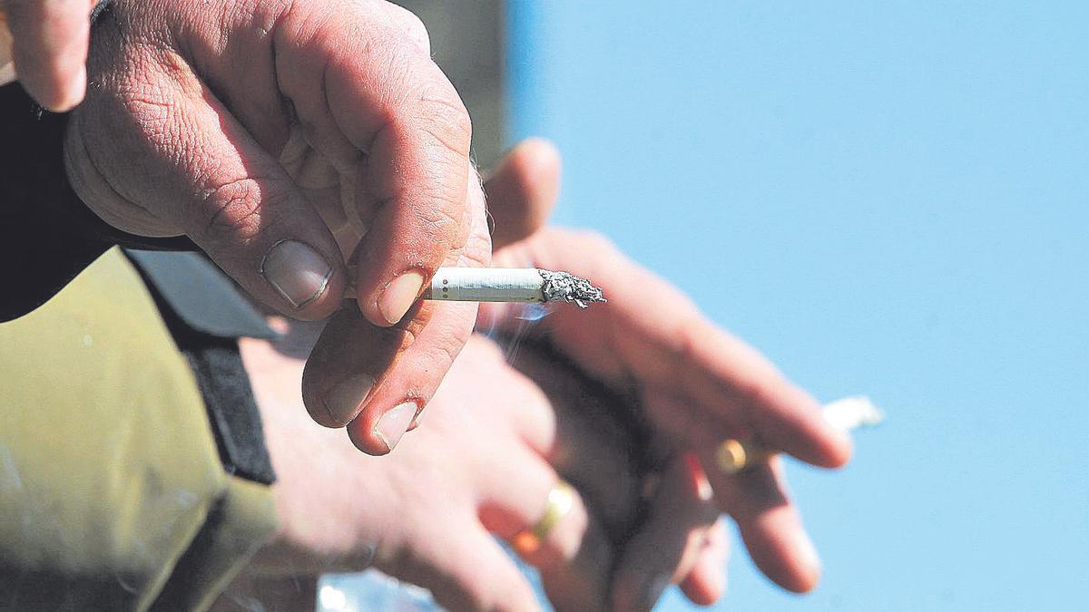 Dos varones fuman en un espacio público de la ciudad de Ourense