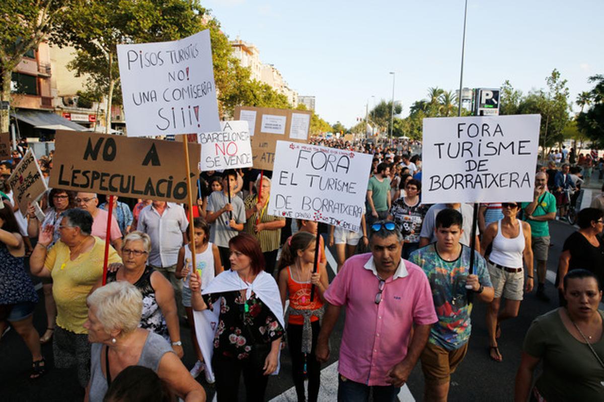 Vecinos con carteles contra los pisos turísticos ilegales y el turismo de borrachera se manifiestan por el paseo Joan de Borbó.