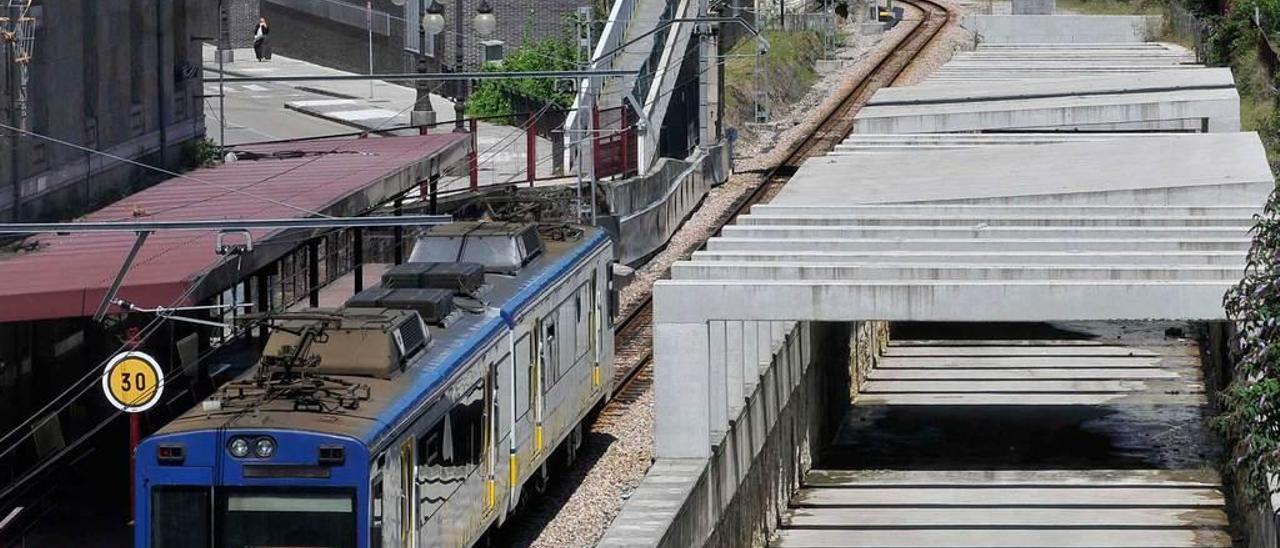 Un convoy de Feve, con el falso túnel a la derecha, a la altura de la estación de Sama.