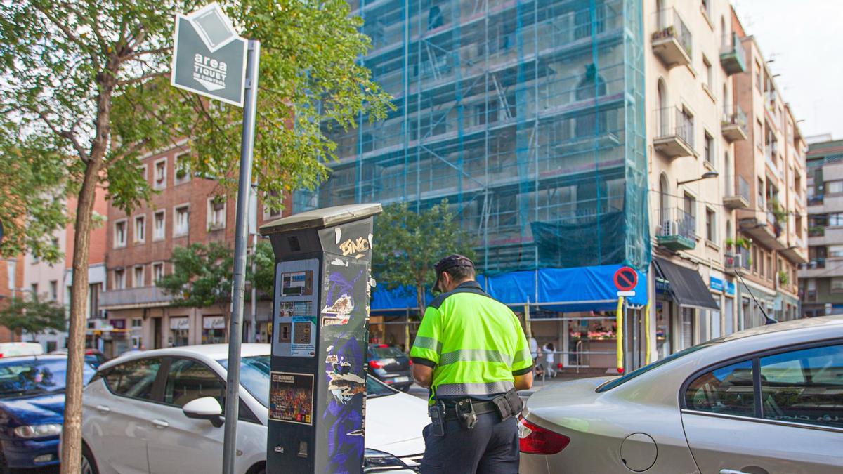 Un vigilante de zona azul y verde de Barcelona controla los vehículos aparcados