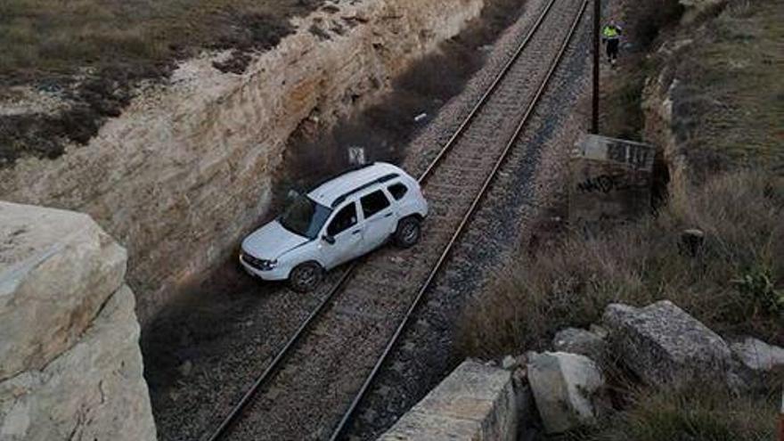 El vehículo accidentado en las vías del tren.