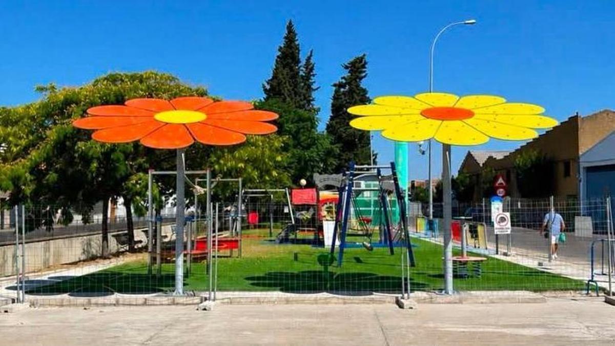 Dos grandes flores dan sombra y color al parque infantil de la avenida Espronceda.