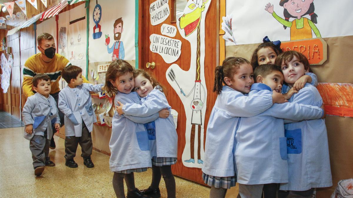 Un grupo de pequeños abrazándose en un aula