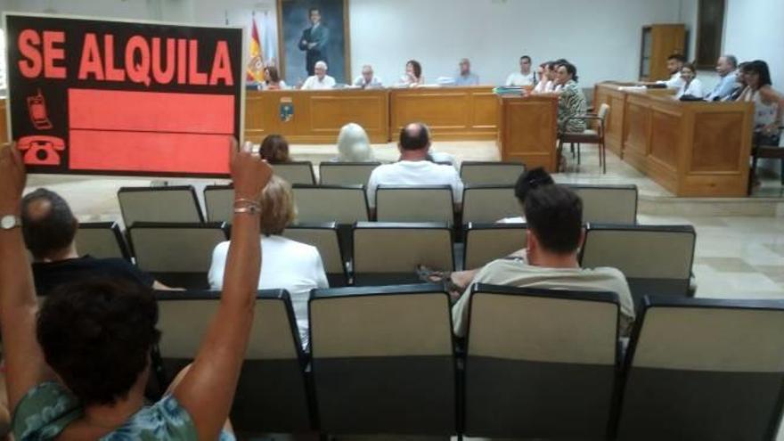 Una vecina de Punta Margalla en contra de la playa canina muestra un cartel de protesta en el pleno de Torrevieja.