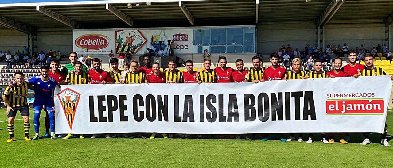 Los equipos salieron al campo con una pancarta de apoyo a La Palma-