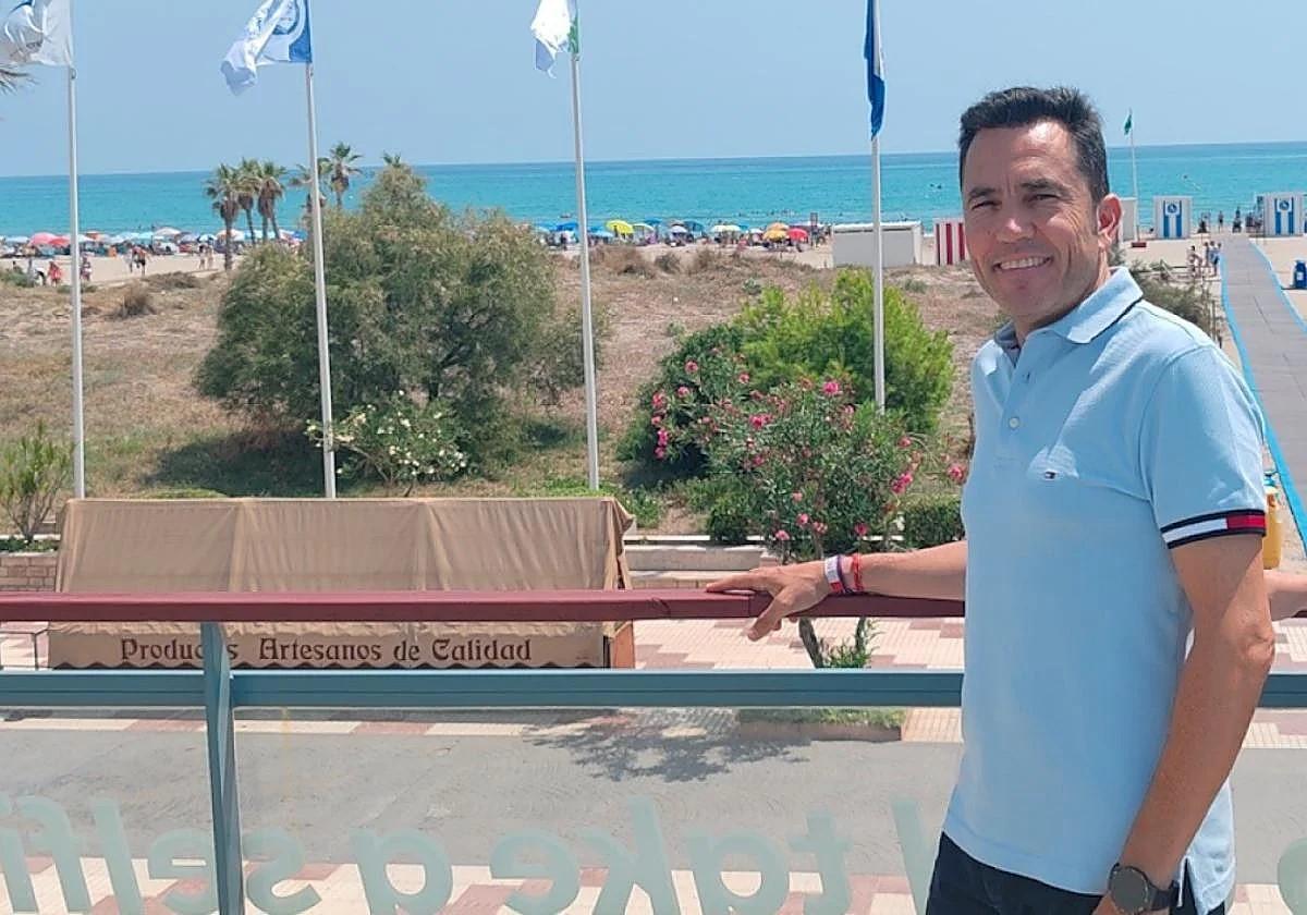 El alcalde mostrando la playa y las banderas