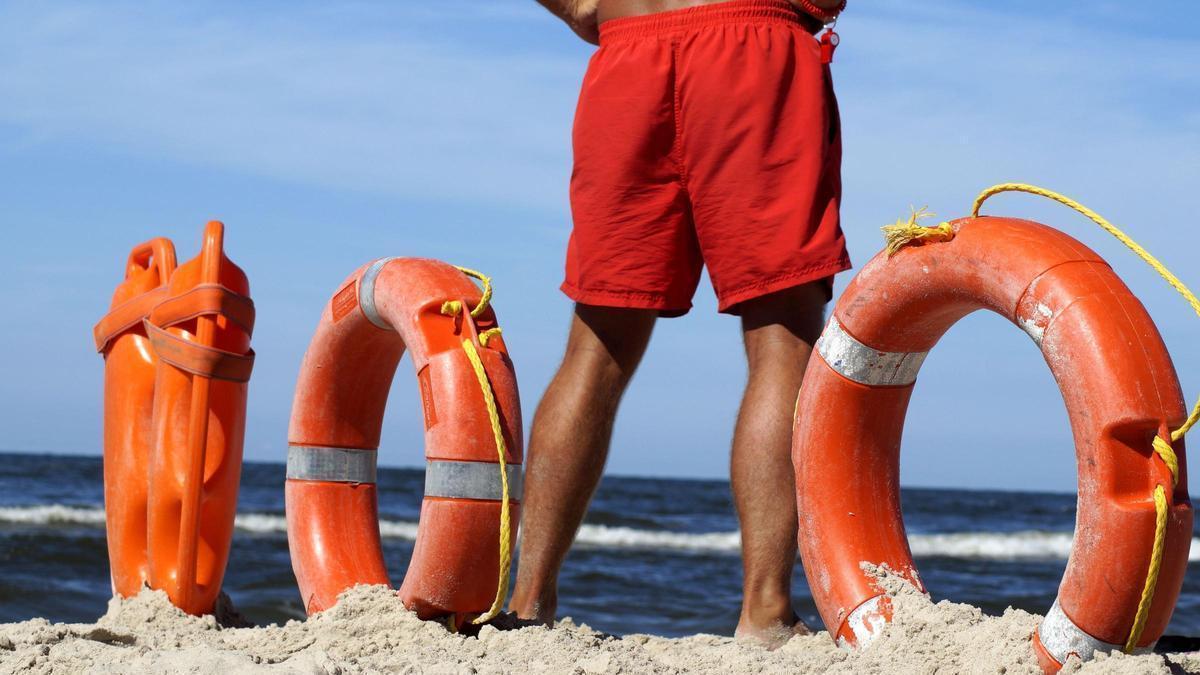 Material de salvamento junto a un socorrista en una playa, preparado para intervenir ante cualquier emergencia en el mar