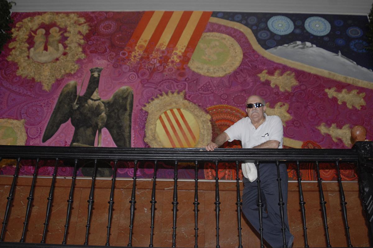 Ortuño con el enorme dibujo que preside el acceso al salón de plenos del Ayuntamiento de Orihuela, obra suya.