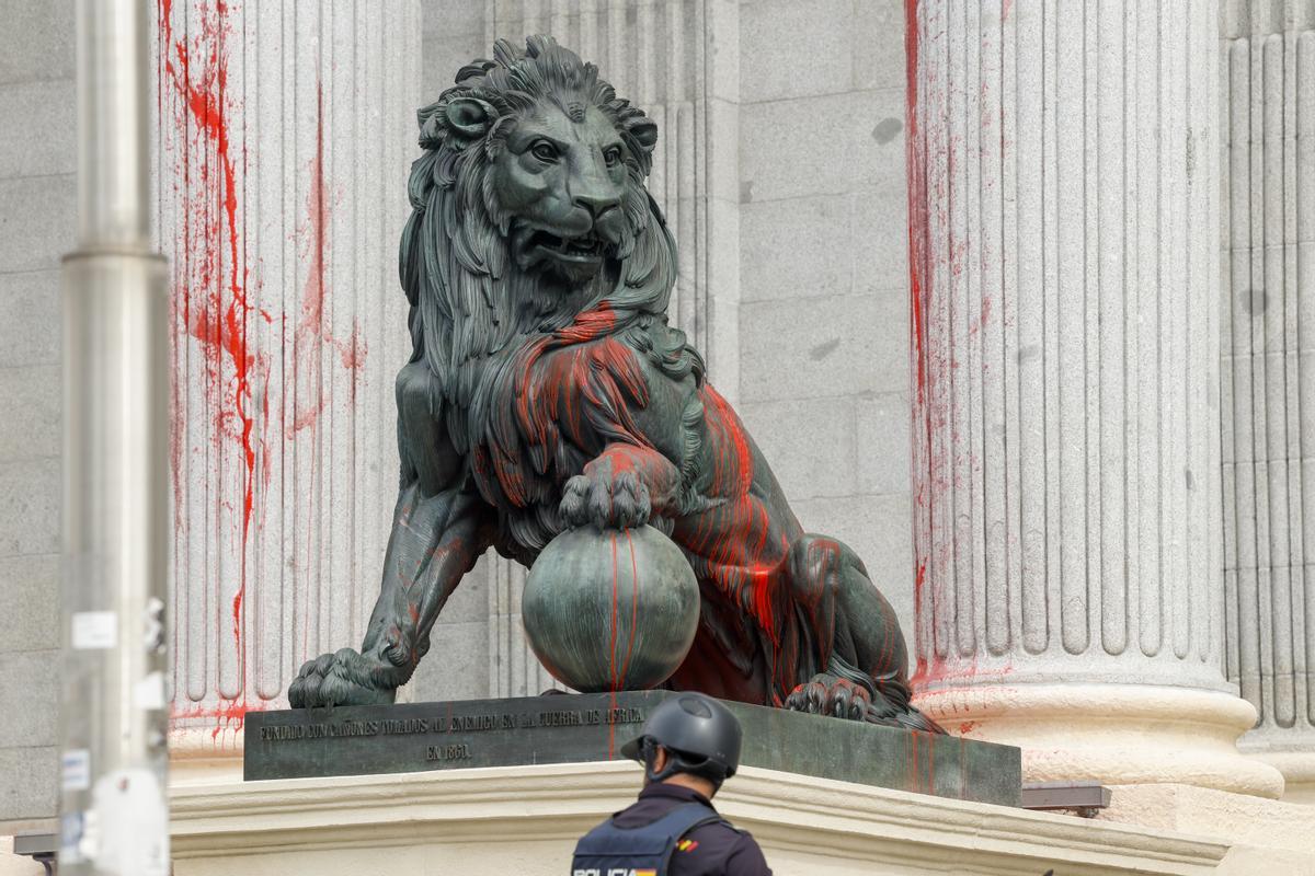 Uno de los leones del Congreso, cubierto con pintura roja después de una acción reivindicativa de Rebelión Científica este jueves en Madrid. EFE/ J.J. Guillén