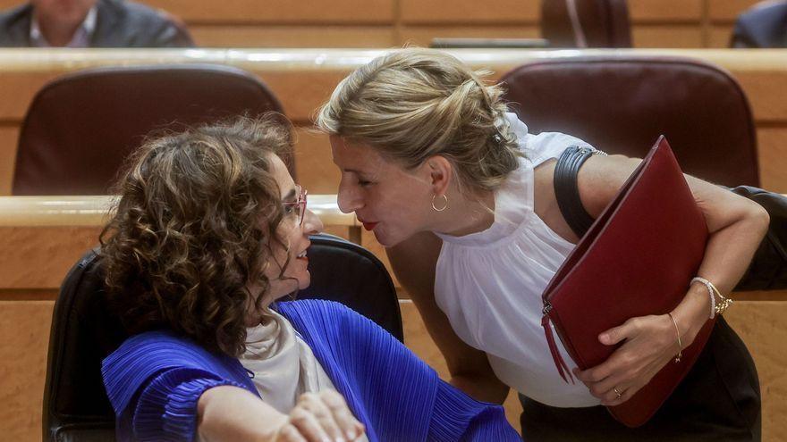 La vicepresidenta segunda del Gobierno y ministra de Trabajo, Yolanda Díaz, y la ministra de Hacienda y Función Pública, María Jesús Montero, conversan en una sesión plenaria en el Senado, a 7 de junio de 2022.