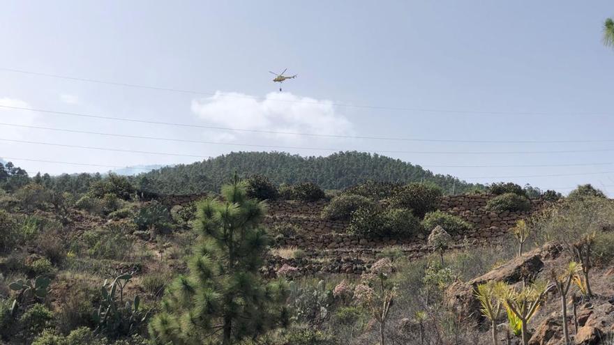 Uno de los helicópteros que trabaja en las labores de extinción recoge agua para apagar el incendio de Arico.