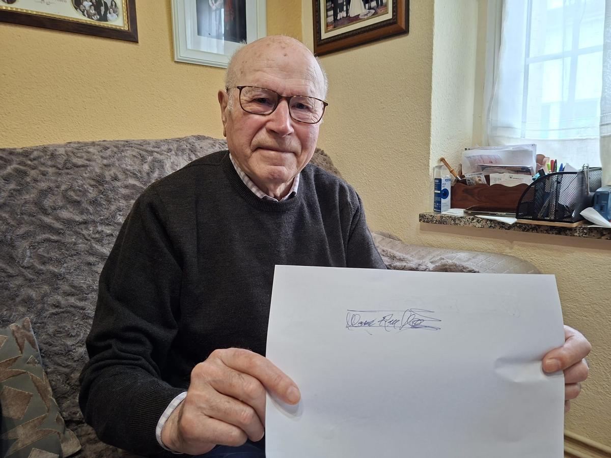 Manuel Ron muestra su firma.
