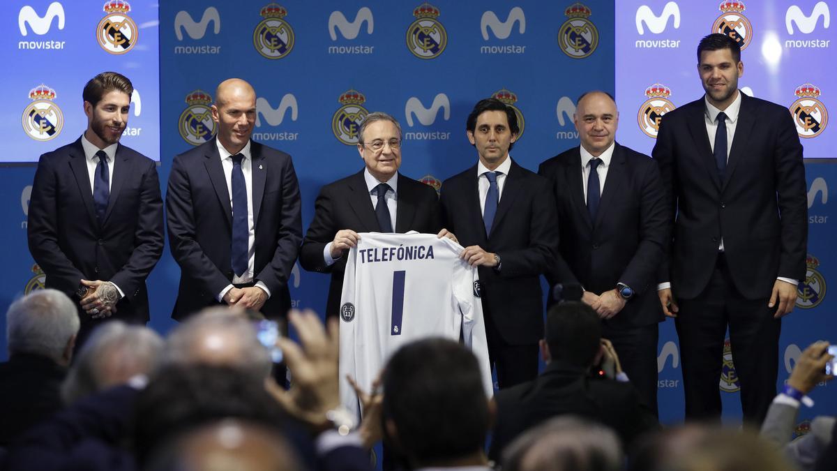 Florentino, durante la firma del acuerdo con Teléfonica, junto al presidente de la compañía, Álvarez-Pallete y los técnicos y capitanes de las secciones de fútbol y baloncesto