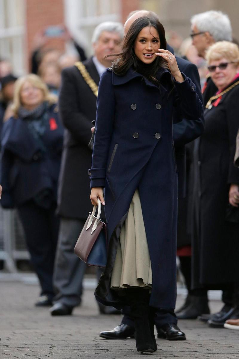 Meghan Markle con falda midi, abrigo largo y bolso