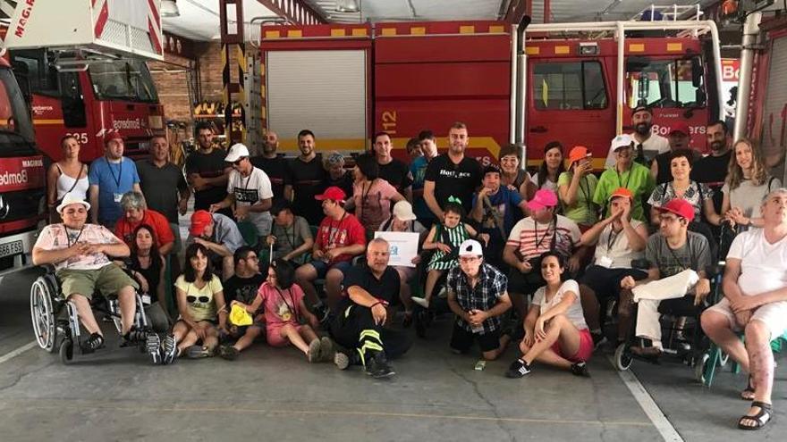 Grupo de usuarios de Aprosdeco junto a los bomberos.