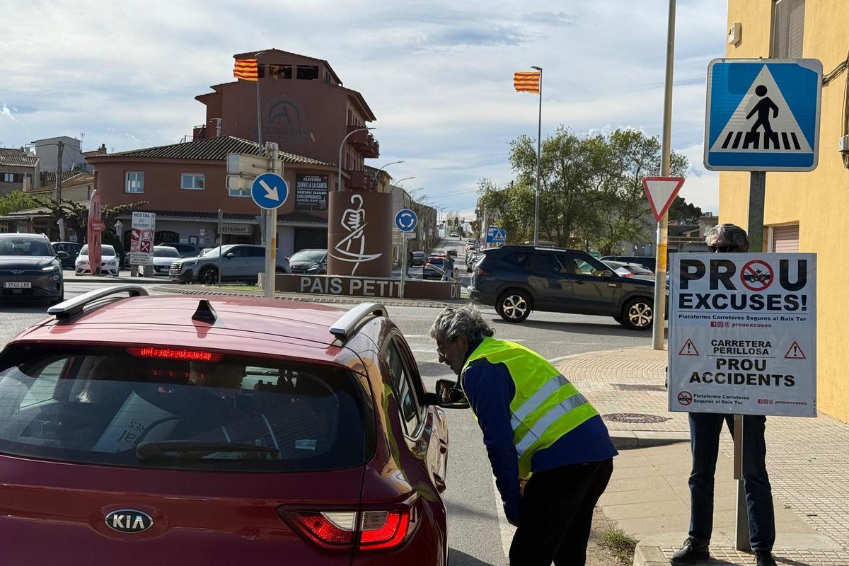 Dos dels manifestants donant una papereta a un conductor a l'entrada de Verges