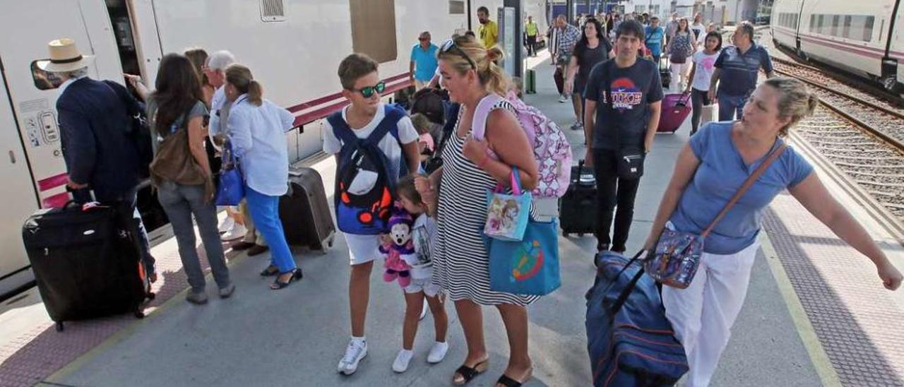 Viajeros subiendo, ayer, al tren de Madrid que partió también completo de la estación viguesa de Guixar. // Marta G. Brea