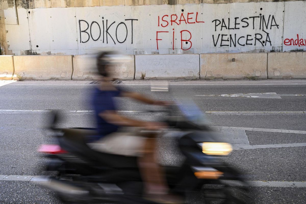 Detalle de una pintada en una de las vías de acceso al recinto del Festival Internacional de Benicàssim (FIB) que abre este jueves una edición cargada de controversia tras la renuncia de siete nombres del cartel, que se han retirado en protesta por la vinculación del festival con el fondo de inversión proisraelí KKR. EFE/Andreu Esteban