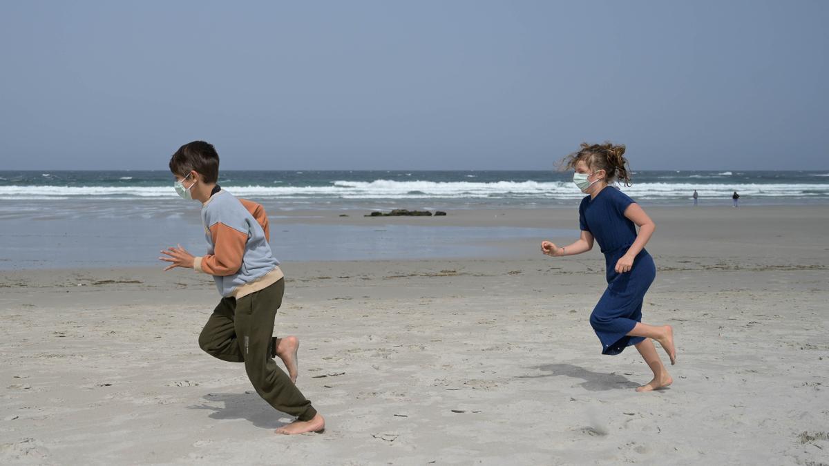 Dos niños con mascarilla en la playa de As Salseiras, en A Laracha.