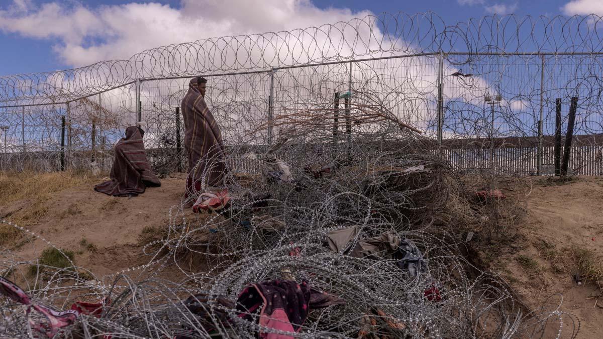 Migrantes acampan a lo largo de la orilla del río Grande mientras esperan entregarse a las autoridades de inmigración en El Paso, Texas, EE.UU