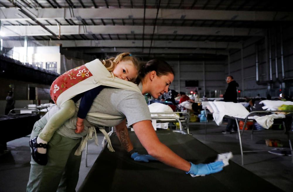 Una voluntaria neteja llits amb la seva filla a coll pels evacuats de l'incendi de Fort McMurray (Canadà)