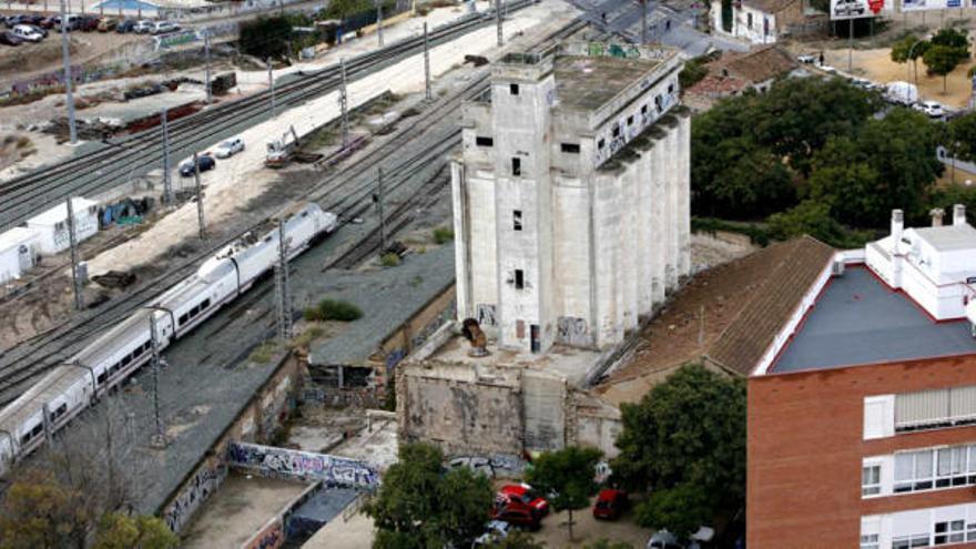 Un tren pasa junto al silo harinero de San Blas en una imagen de archivo. La llegada del AVE acabará con el viejo inmueble industrial.