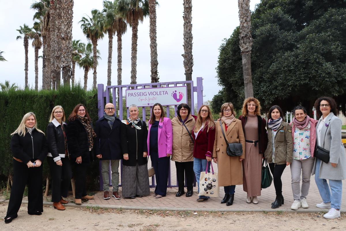 Comitiva de mujeres y corporación con las dos ganadoras en el paseo Violeta.