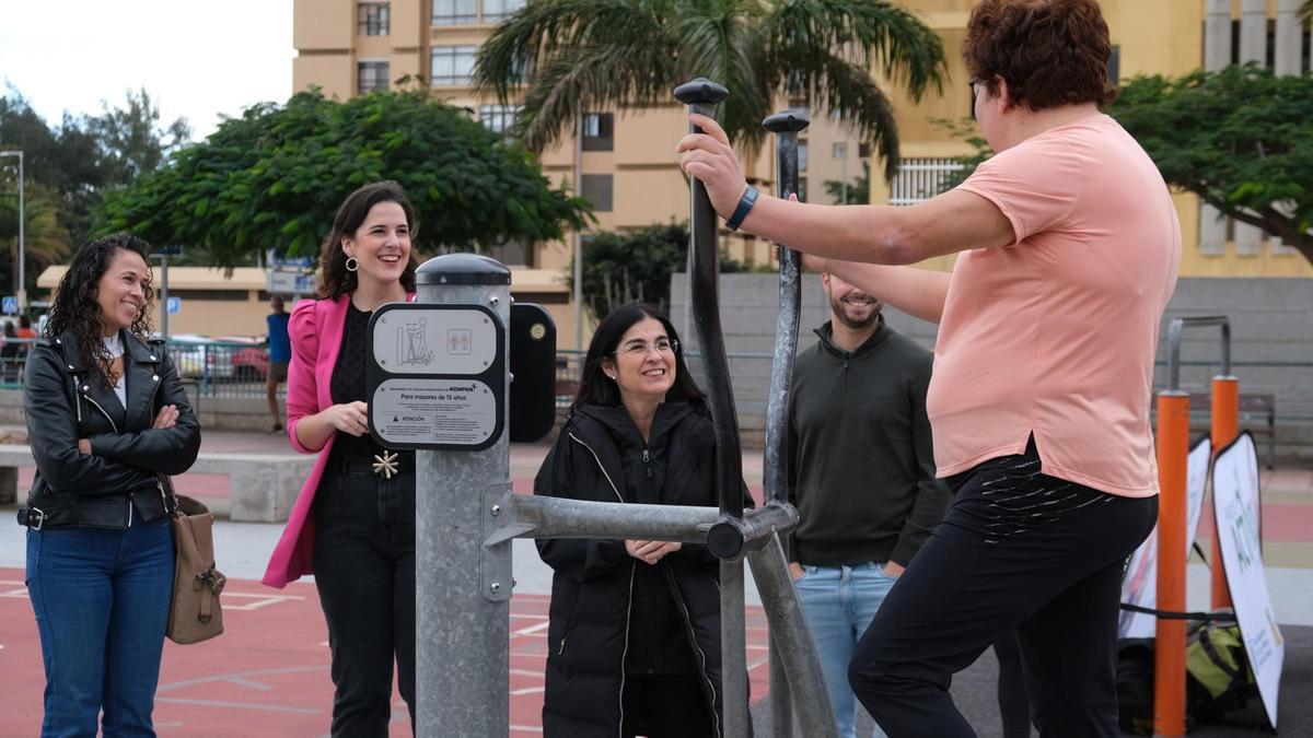 Carolina Darias y Carla Campoamor conversan con una usuaria utiliza un equipo biosaludable en el parque de la Vega de San José.