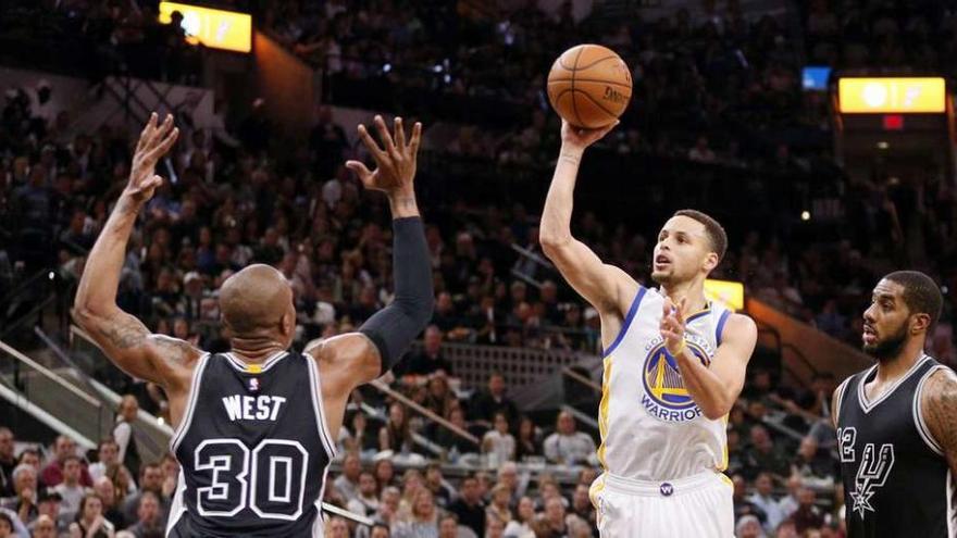 Curry, que anotó 37 puntos, lanza a canasta pese a la oposición de West.
