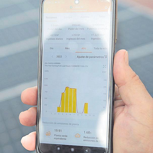 Un vecino consulta la aplicación del móvil que le permite conocer el rendimiento de la instalación fotovoltaica comunitaria instalada en la azotea.