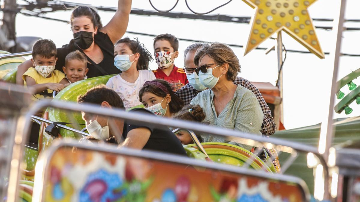 Imagen de una familia disfrutando de una atracción de la feria en Cáceres.