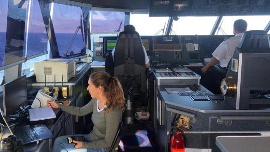 Una investigadora comprueba la grabación de imágenes con la cámara térmica con el capitán y su copiloto al fondo de la imagen.