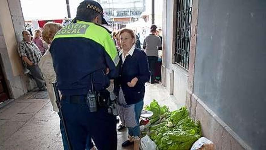Un agente de la Policía Local charlando con una vendedora de la plaza de abastos.