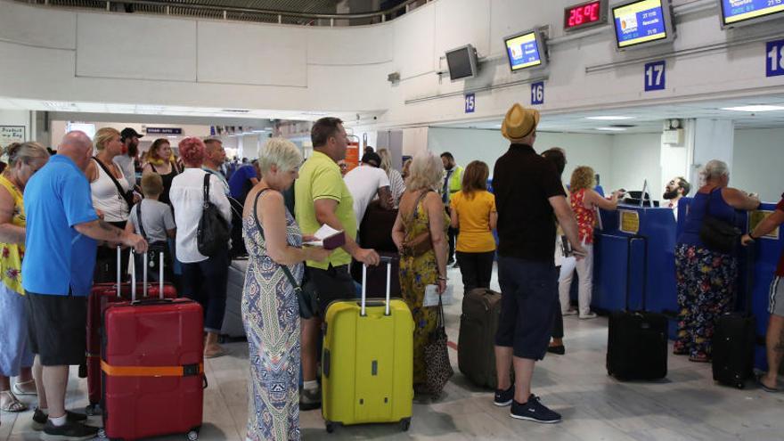 Pasajeros de Thomas Cook ante el mostrador de facturación.