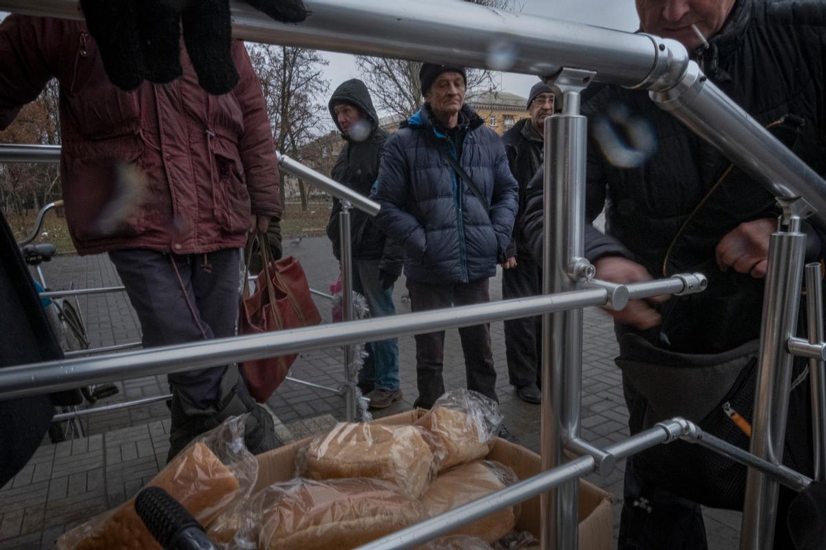 Habitantes de Bajmut acuden a un centro de reparto de comida.