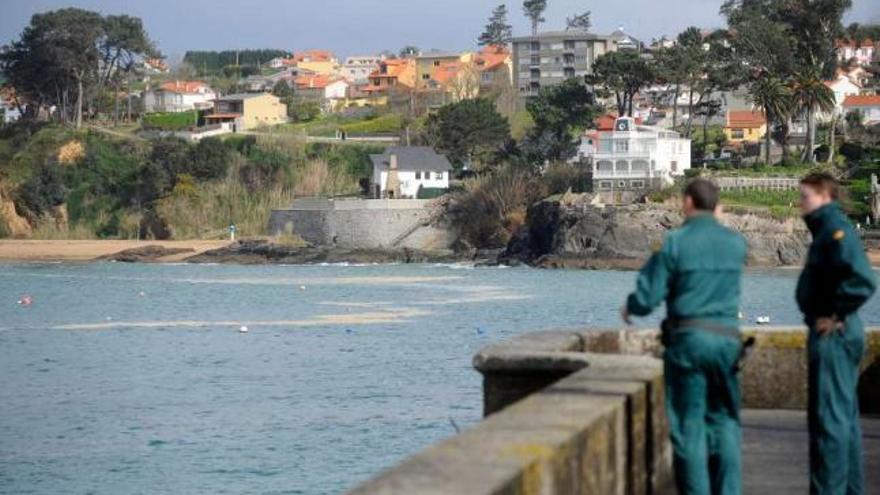 Dos agentes del Seprona observan un vertido en la costa coruñesa en abril de 2010. / juan varela