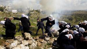 Un grupo de mujeres palestinas trata de escapar de los gases lacrimógenos lanzados por soldados israelís durante una protesta en contra de la construcción del muro de seguridad. Deir Qaddis, Cisjordania. 2004. Fotografía del reportaje ’La intifada del muro’.