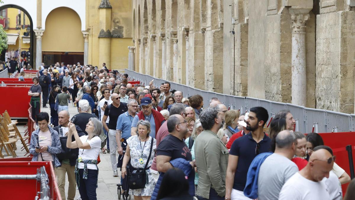 Turistas pasean frente a los palcos de Semana Santa en la Mezquita Catedral.