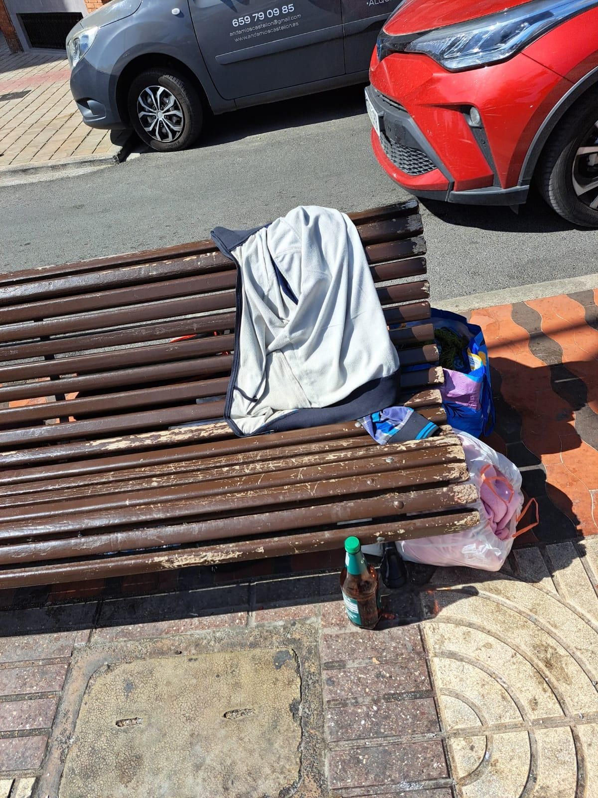 Pertenencias en un banco cercano al centro.