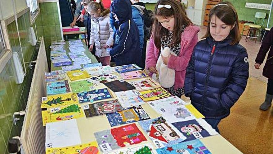 Varios alumnos observan las tarjetas para elegir la ganadora.