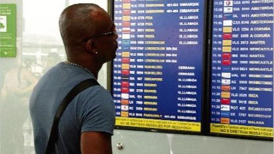 Un passatger, consultant les previsions de vols a l&#039;aeroport del Prat de Barcelona.